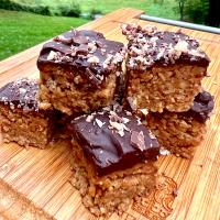 No-bake almond butter bars with chocolate ganache and crushed Heath bar topping